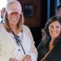 Two attendees at event smiling and looking off camera
